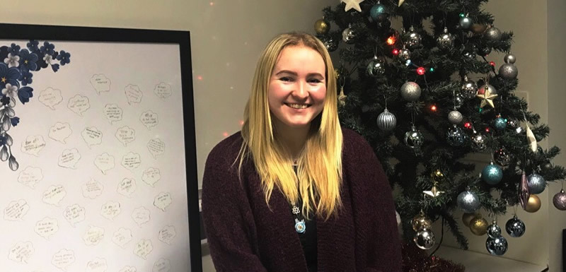 Ashleigh next to a christmas tree