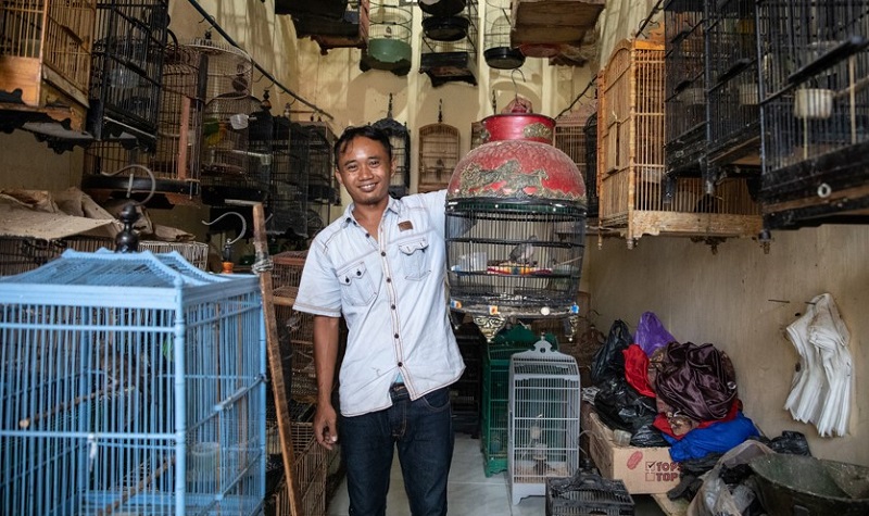 A man holds up his pet songbird. Photo: Gabby Salazar 