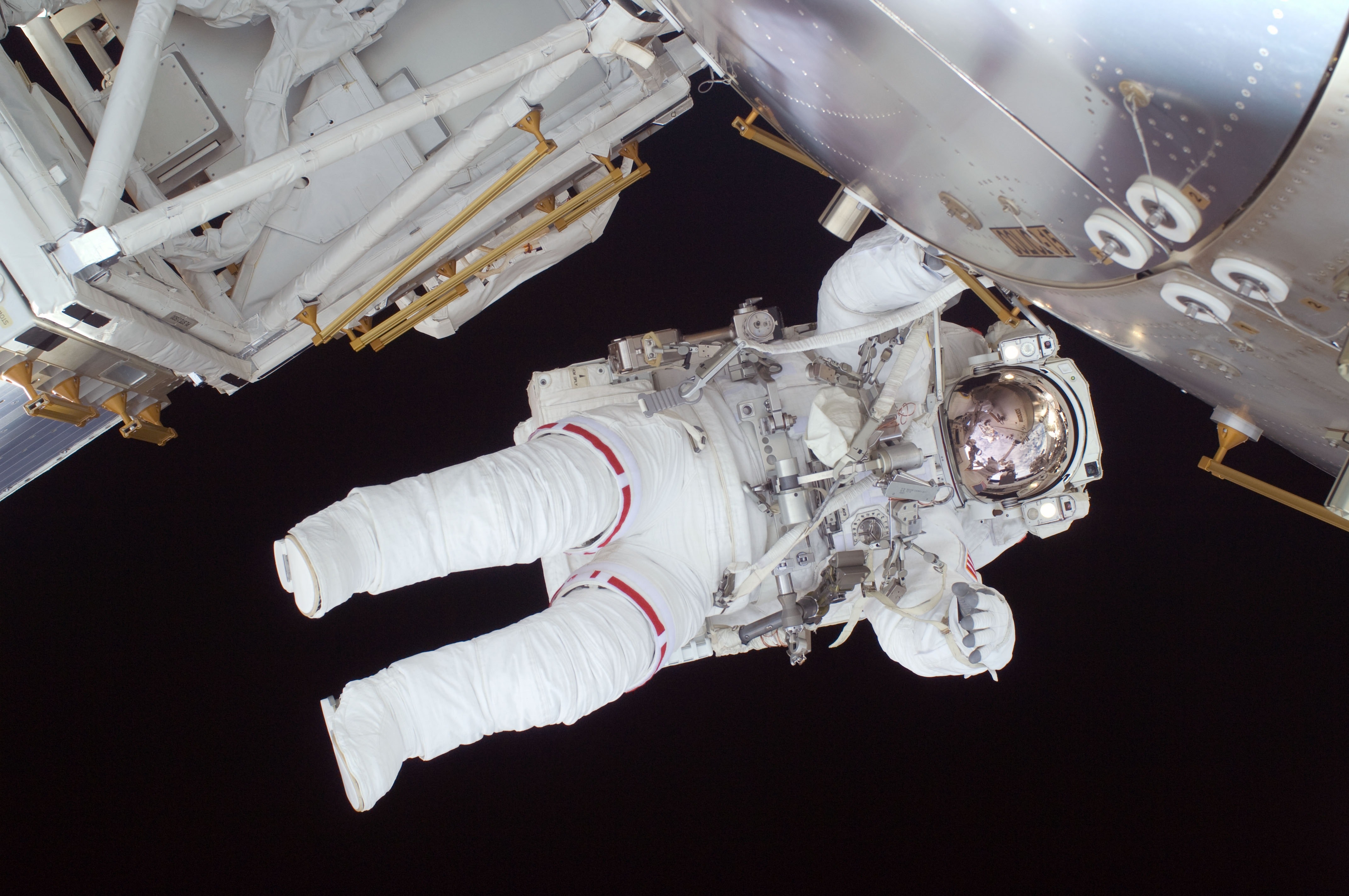 Image shows astronaut floating outside of space shuttle