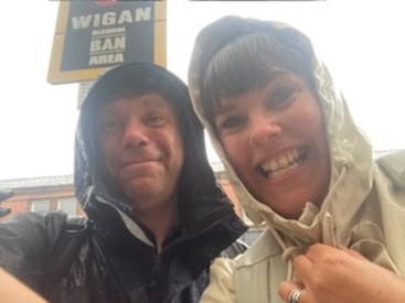 Hannah Smithson and Tom Lang stand together with raincoats on