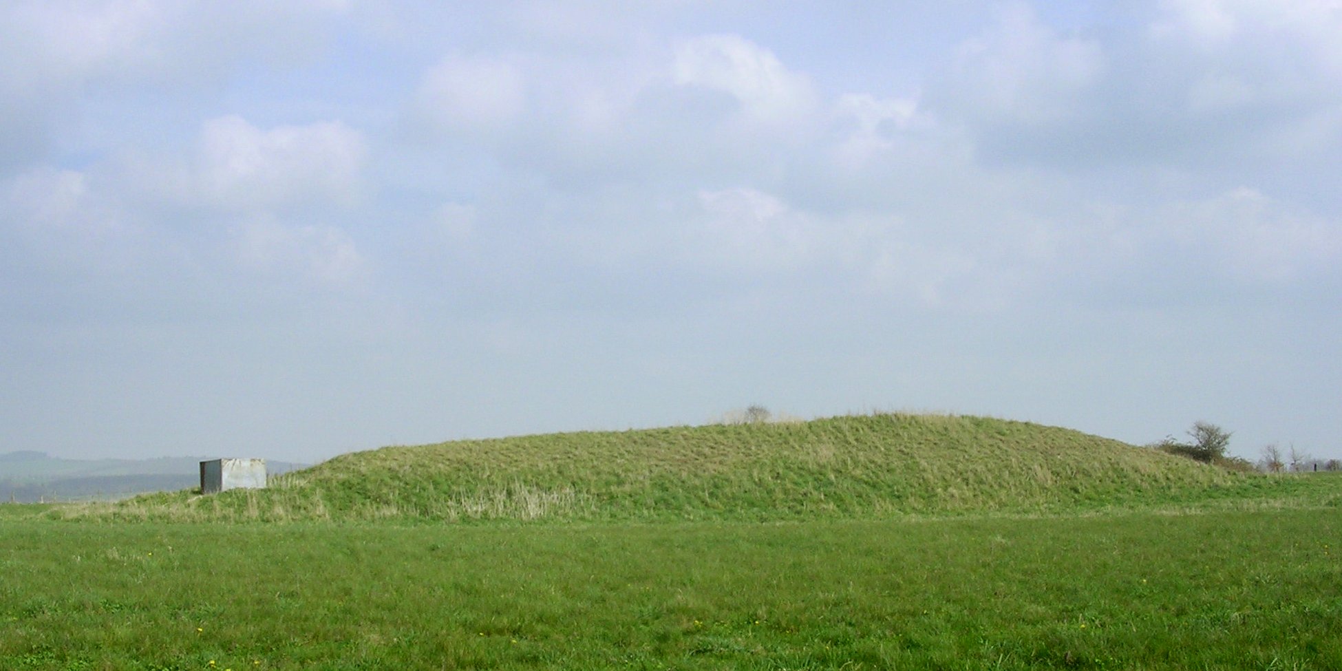 Picture of a earthen long barrow - a large grassy mound - in Dorset